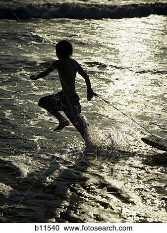 Boy running on beach with boogie board View Large Photo Image Stock Image - Boy running on beach with boogie board. Fotosearch