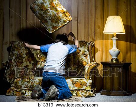 Stock Photo - Boy searching under sofa cushions. Fotosearch