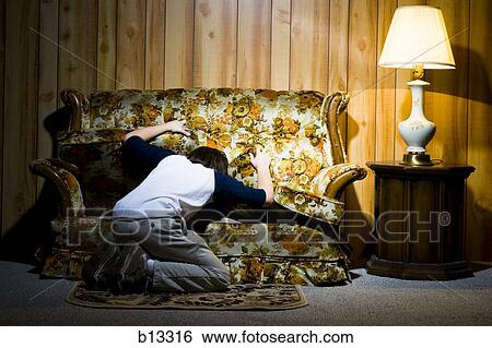 Boy searching under sofa cushions View Large Photo Image Stock Photograph - Boy searching under sofa cushions. Fotosearch