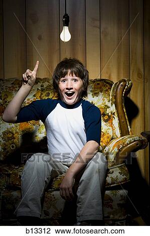 Boy sitting on sofa with light bulb idea View Large Photo Image Stock Image - Boy sitting on sofa with light bulb idea. Fotosearch