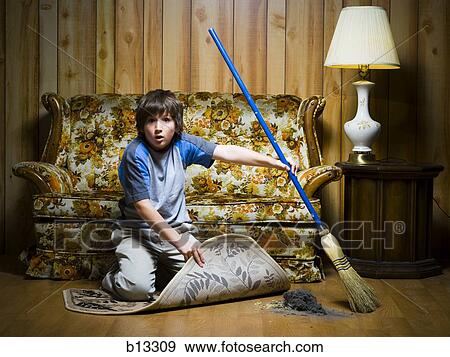 Boy sweeping dirt under rug View Large Photo Image Stock Photo - Boy sweeping dirt under rug. Fotosearch