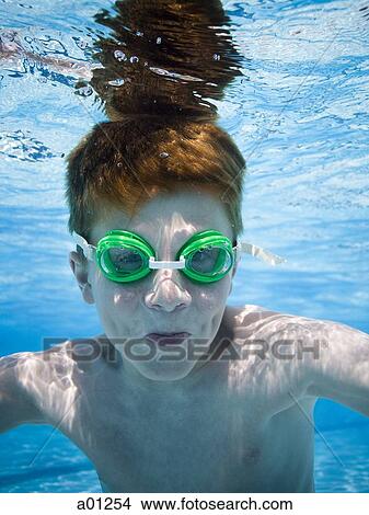 Picture - Boy swimming underwater in pool. Fotosearch