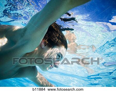 Picture - Boy swimming underwater in pool. Fotosearch
