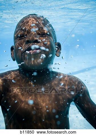 Stock Image - Boy swimming underwater in pool. Fotosearch