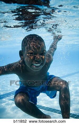 Boy swimming underwater in pool View Large Photo Image Stock Image - Boy swimming underwater in pool. Fotosearch