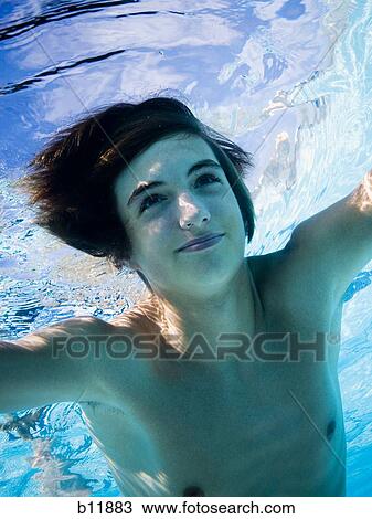 Stock Image - Boy swimming underwater in pool. Fotosearch