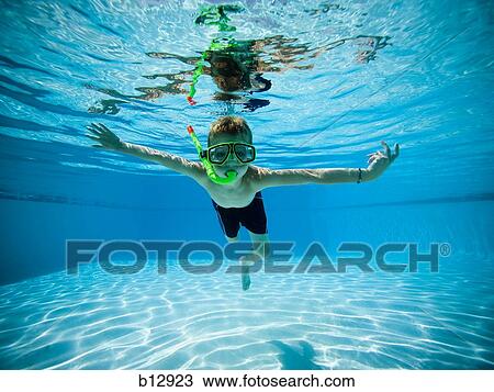 Stock Image - Boy swimming underwater in pool. Fotosearch
