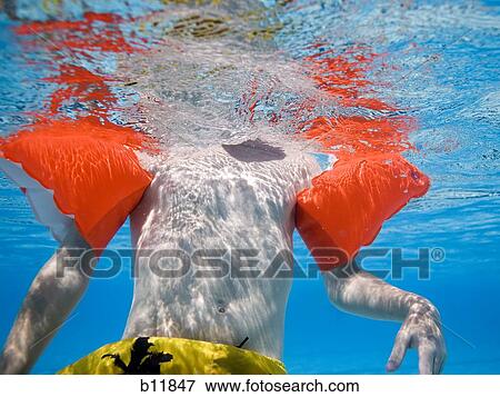 Boy swimming underwater in pool View Large Photo Image Stock Photo - Boy swimming underwater in pool. Fotosearch