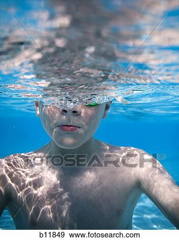 Boy swimming underwater in pool View Large Photo Image Stock Photo - Boy swimming underwater in pool. Fotosearch