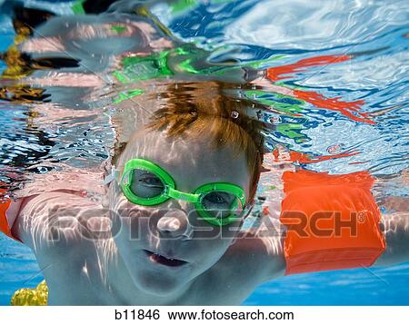 Boy swimming underwater in pool View Large Photo Image Stock Photograph - Boy swimming underwater in pool. Fotosearch