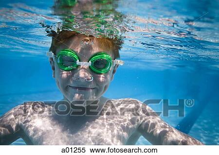 Boy swimming underwater in pool View Large Photo Image Stock Photography - Boy swimming underwater in pool. Fotosearch