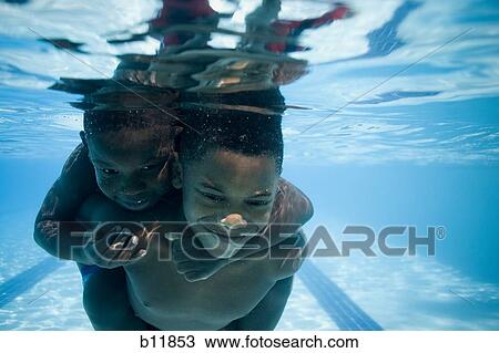 Boys swimming underwater in pool View Large Photo Image Stock Image - Boys swimming underwater in pool. Fotosearch