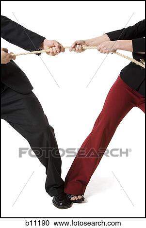 Stock Image - Business people engaged in a tug of war contest. Fotosearch