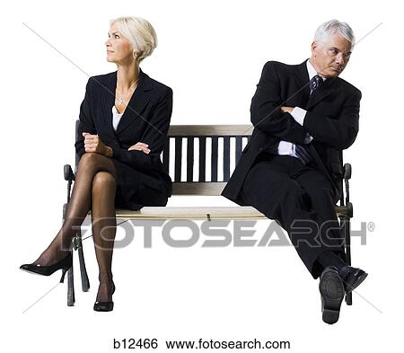 Businessman and businesswoman sitting on a bench View Large Photo Image Stock Photograph - Businessman and businesswoman sitting on a bench. Fotosearch