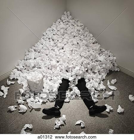 Standartiniai vaizdai - Businessman buried in mountain of crumpled papers. Fotosearch