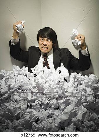 Stock Photography - Businessman buried in mountain of crumpled papers. Fotosearch