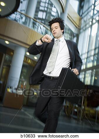 Businessman checking the time View Large Photo Image Stock Image - Businessman checking the time. Fotosearch