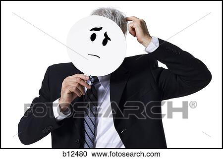 Businessman holding a confused face mask View Large Photo Image Stock Image - Businessman holding a confused face mask. Fotosearch
