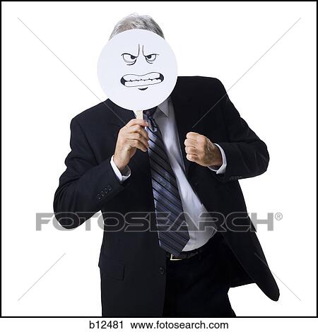 Businessman holding a determined face mask View Large Photo Image Stock Image - Businessman holding a determined face mask. Fotosearch