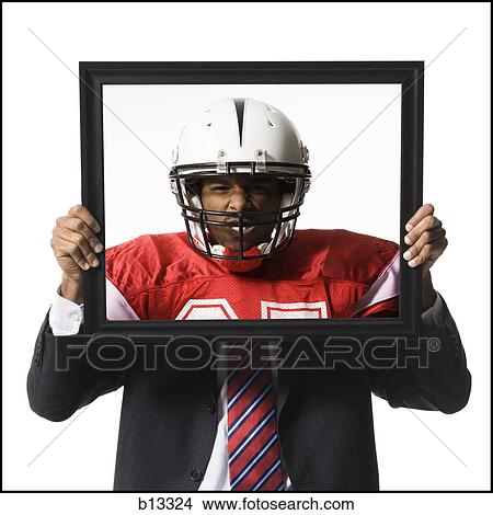 Businessman holding picture of football player with helmet View Large Photo Image Picture - Businessman holding picture of football player with helmet. Fotosearch