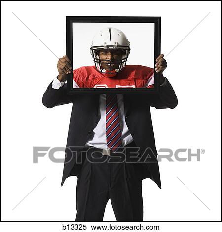 Stock Photography - Businessman holding picture of football player with helmet. Fotosearch