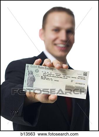 Businessman holding US Treasury check View Large Photo Image Stock Image - Businessman holding US Treasury check. Fotosearch