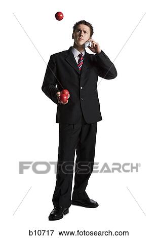 Stock Photo - Businessman juggling while talking on phone. Fotosearch