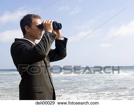 Businessman looking through binoculars outdoors View Large Photo Image Stock Photo - Businessman looking through binoculars outdoors. Fotosearch