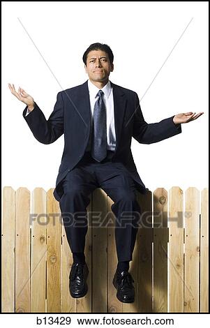 Businessman on wooden fence shrugging View Large Photo Image Stock Photo - Businessman on wooden fence shrugging. Fotosearch