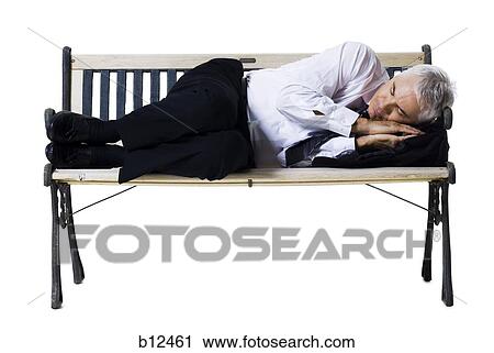 Stock Image - Businessman sleeping on a bench. Fotosearch
