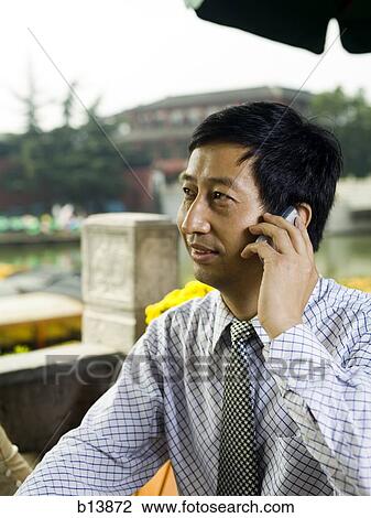 Businessman talking on cell phone outdoors View Large Photo Image Stock Image - Businessman talking on cell phone outdoors. Fotosearch