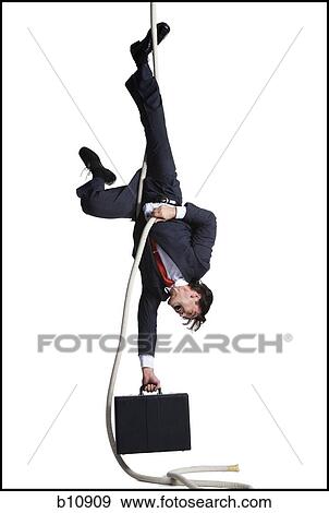 Businessman with briefcase dangling upside down from a rope View Large Photo Image Stock Photo - Businessman with briefcase dangling upside down from a rope. Fotosearch