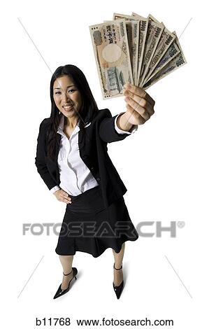 Businesswoman holding Yen banknotes View Large Photo Image Stock Photo - Businesswoman holding Yen banknotes. Fotosearch