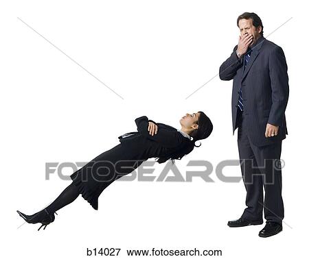 Stock Photo - Businesswoman levitating with businessman yawning. Fotosearch