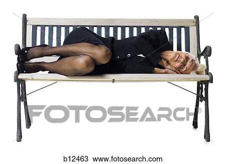 Stock Image - Businesswoman sleeping on bench. Fotosearch
