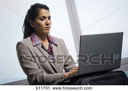 Stock Image - Businesswoman working on laptop computer. Fotosearch