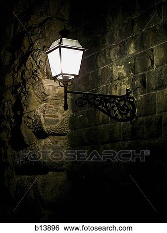 Stock Photograph - Carriage lamp on brick wall at night. Fotosearch