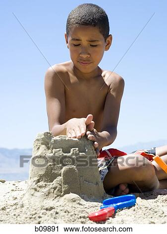Close-up of a boy making a sand castle View Large Photo Image Stock Image - Close-up of a boy making a sand castle. Fotosearch