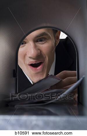 Close-up of a businessman looking into a mailbox View Large Photo Image Stock Image - Close-up of a businessman looking into a mailbox. Fotosearch