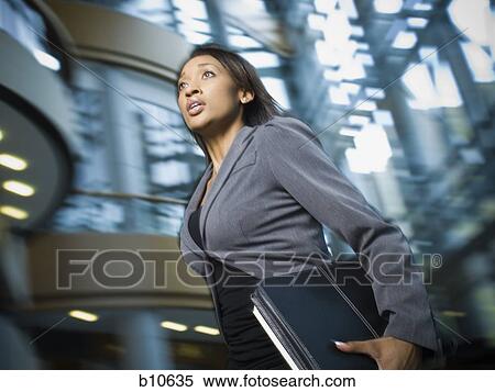 Close-up of a businesswoman carrying files View Large Photo Image Stock Photography - Close-up of a businesswoman carrying files. Fotosearch