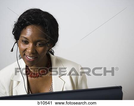 Close-up of a businesswoman using a computer and smiling View Large Photo Image Stock Image - Close-up of a businesswoman using a computer and smiling. Fotosearch