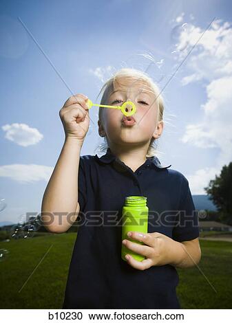 Close-up of a girl blowing bubbles with a bubble wand View Large Photo Image Stock Image - Close-up of a girl blowing bubbles with a bubble wand. Fotosearch