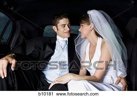 Stock Image - Close-up of a newlywed couple sitting in a car and looking at each other. Fotosearch