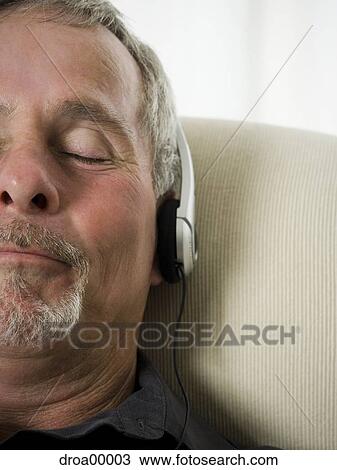 Close-up of a senior man listening to music View Large Photo Image Stock Image - Close-up of a senior man listening to music. Fotosearch