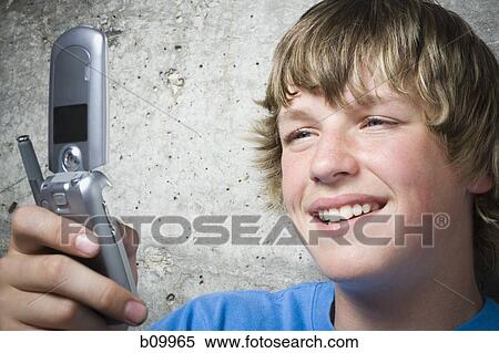 Close-up of a teenage boy using a mobile phone View Large Photo Image Stock Photography - Close-up of a teenage boy using a mobile phone. Fotosearch