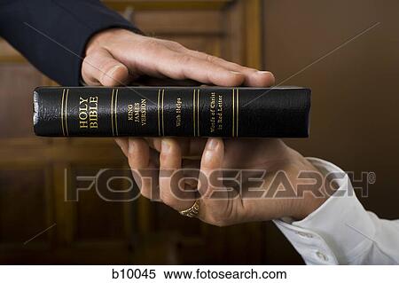 Close-up of a witnesses hand swearing over the Bible View Large Photo Image Stock Photography - Close-up of a witnesses hand swearing over the Bible. Fotosearch