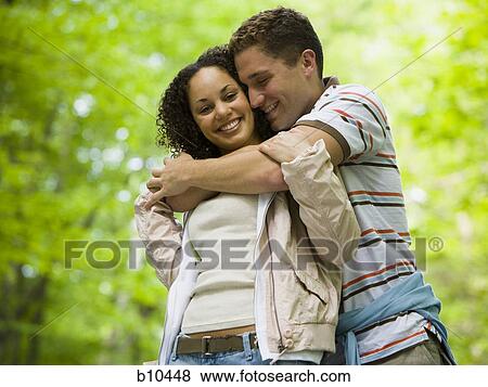 Close-up of a young couple embracing each other View Large Photo Image Stock Photo - Close-up of a young couple embracing each other. Fotosearch