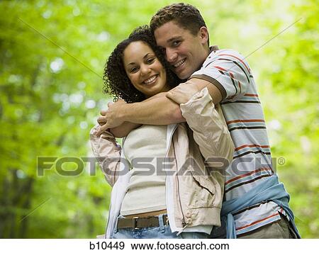 Close-up of a young couple embracing each other View Large Photo Image Stock Photo - Close-up of a young couple embracing each other. Fotosearch