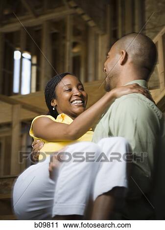 Close-up of a young man carrying a young woman and smiling View Large Photo Image Stock Image - Close-up of a young man carrying a young woman and smiling. Fotosearch