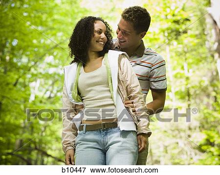 Stock Photo - Close-up of a young man embracing a young woman from behind. Fotosearch